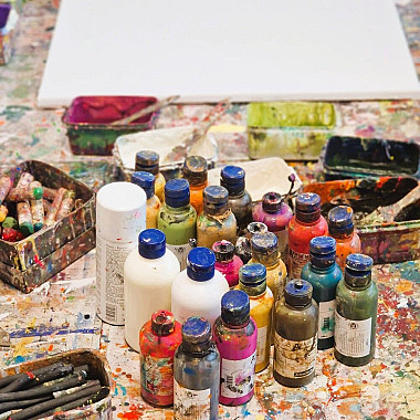 Arbeitstisch mit Farben, Snacks und Getränken bei einem Kunstworkshop