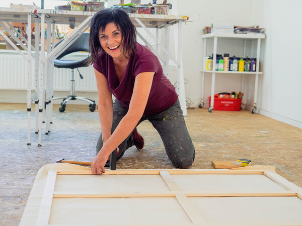 Künstlerin Josefine Frauenschuh im Atelier beim Leinwand bespannen für das Auftragskunstwerk